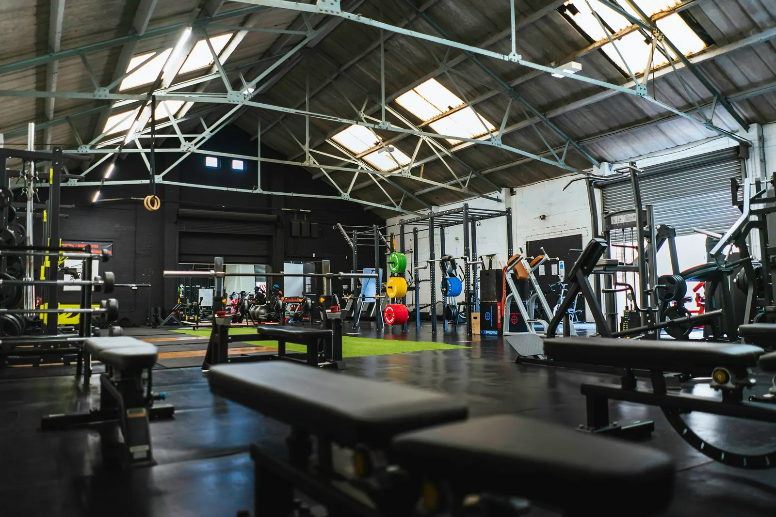 Salle de sport spacieuse, racks et anneaux de gymnastique