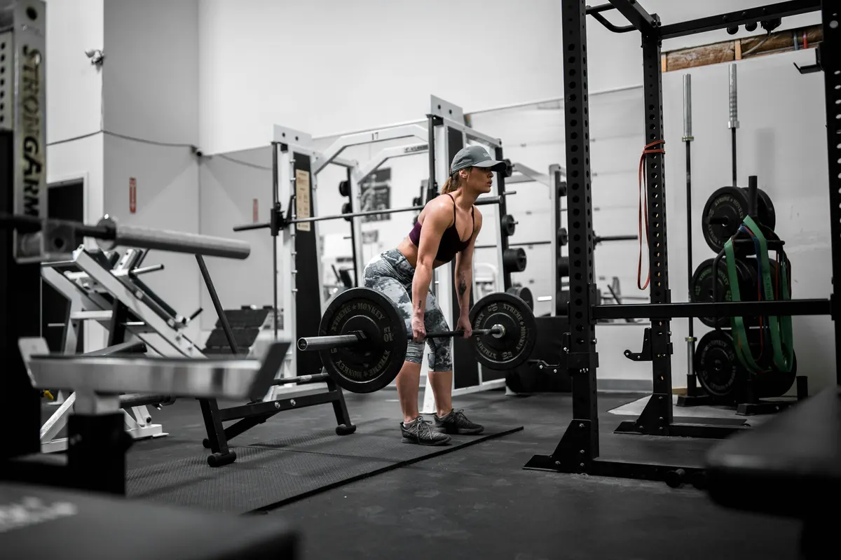 Pratiquante en soulevé de terre dans un rack de musculation