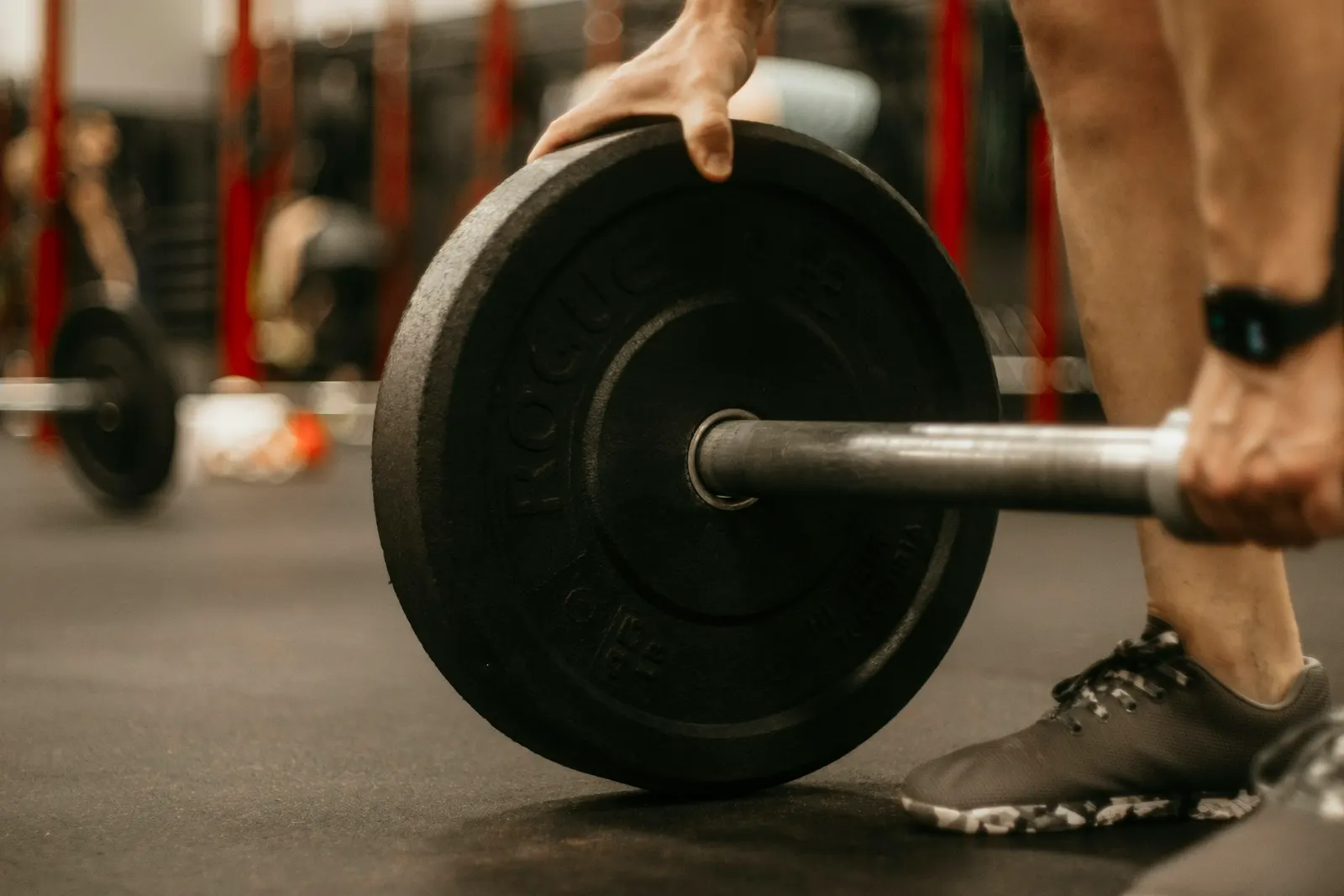 Chargement d'une barre de musculation au sol en salle